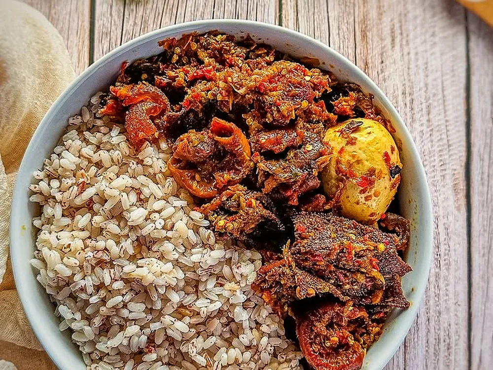 Ofada rice served with green ayamase pepper sauce