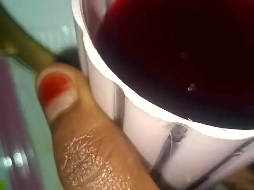 A glass of deep red hibiscus zobo drink